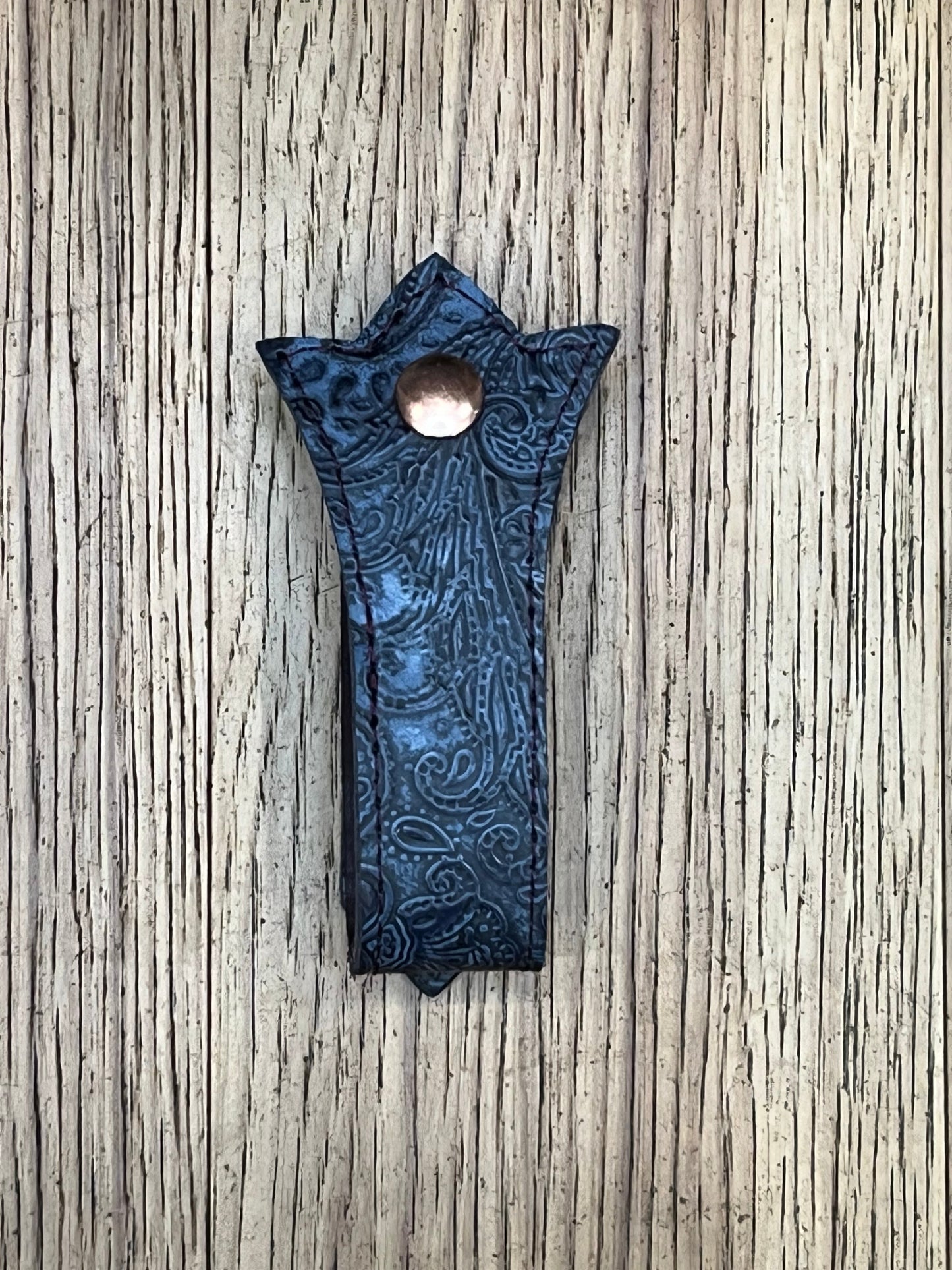 A trident shaped double layered mug frog using blue paisley leather, black stitching and a rose gold snap.