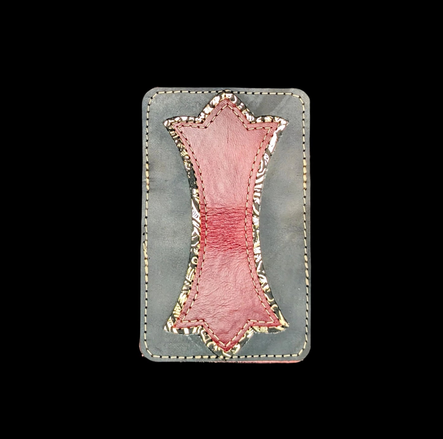 A photo of the outside of a wallet laid flat showing a base color of black leather with a layered trident accent of bronze floral leather and red leather and red and bronze stitching.