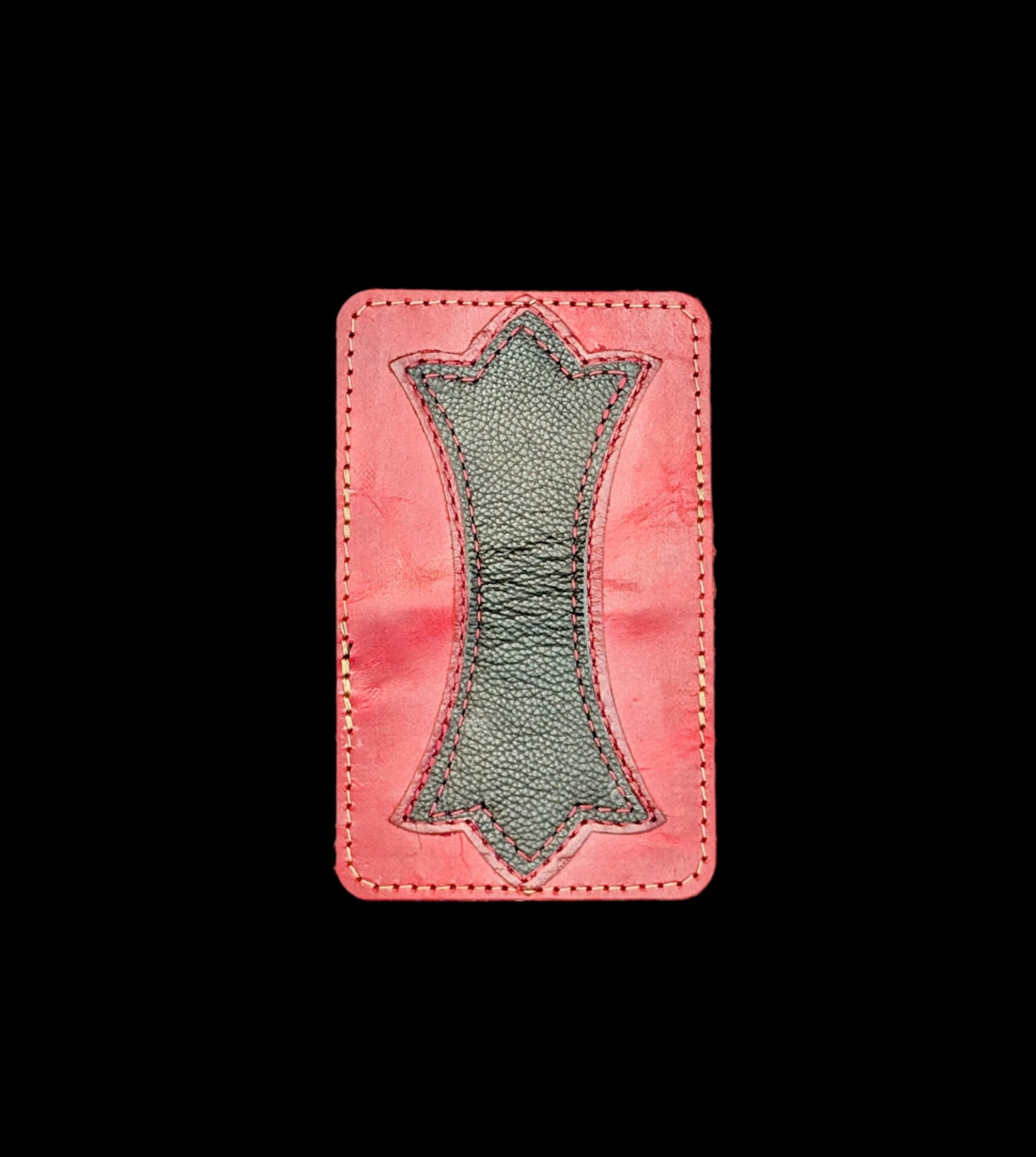 A photo of the outside of a wallet laid flat showing a base color of red leather with a layered trident accent of red leather and black leather and red and bronze stitching.