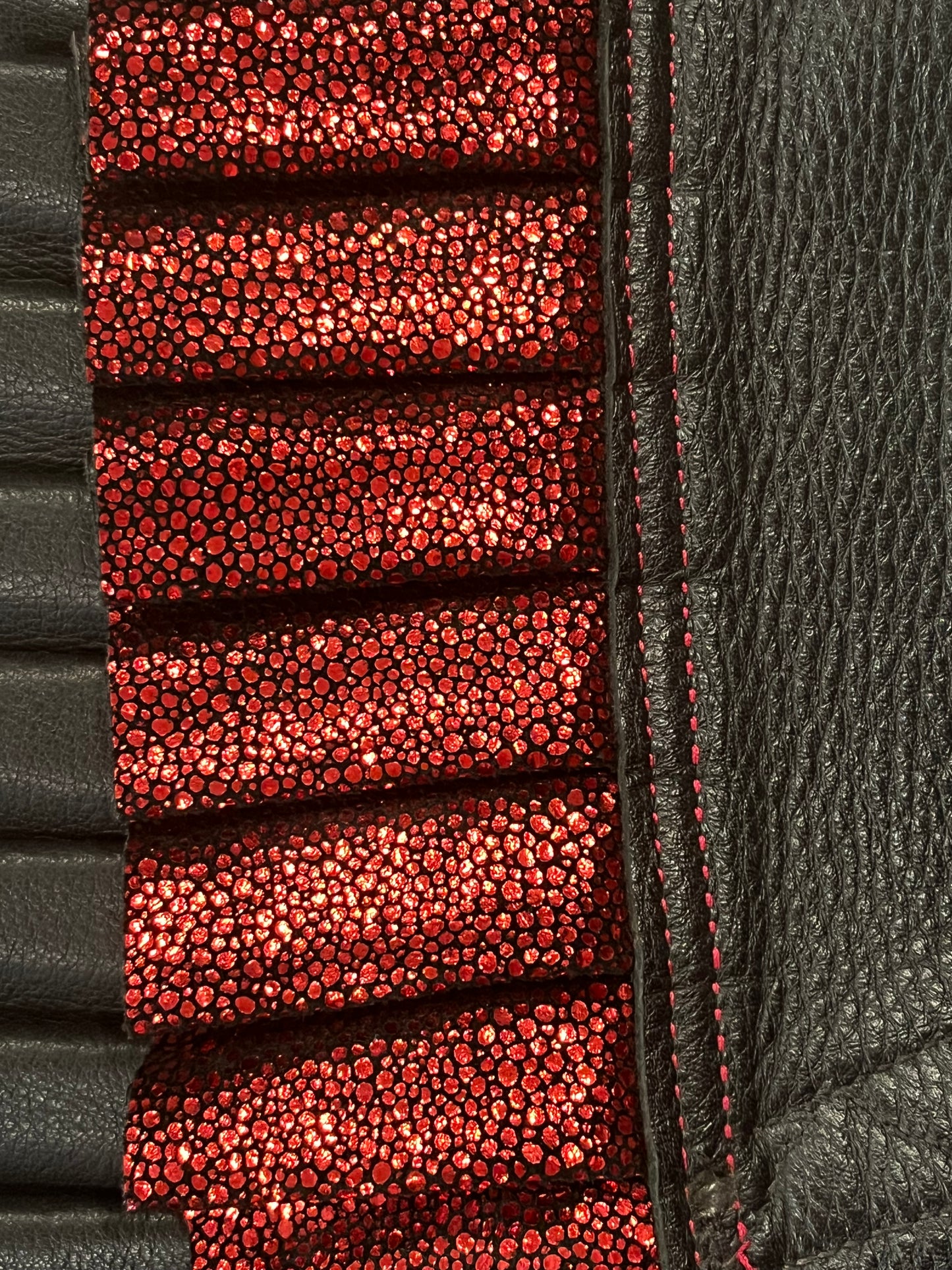 close up of red stingray ruff showing black leather neck, black based "stingray" leather with metallic red texture and red stitching