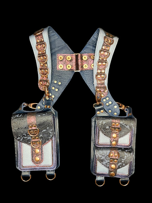 Cordelia holster in blue and maroon metallic leathers and rose gold hardware laid flat on a black background