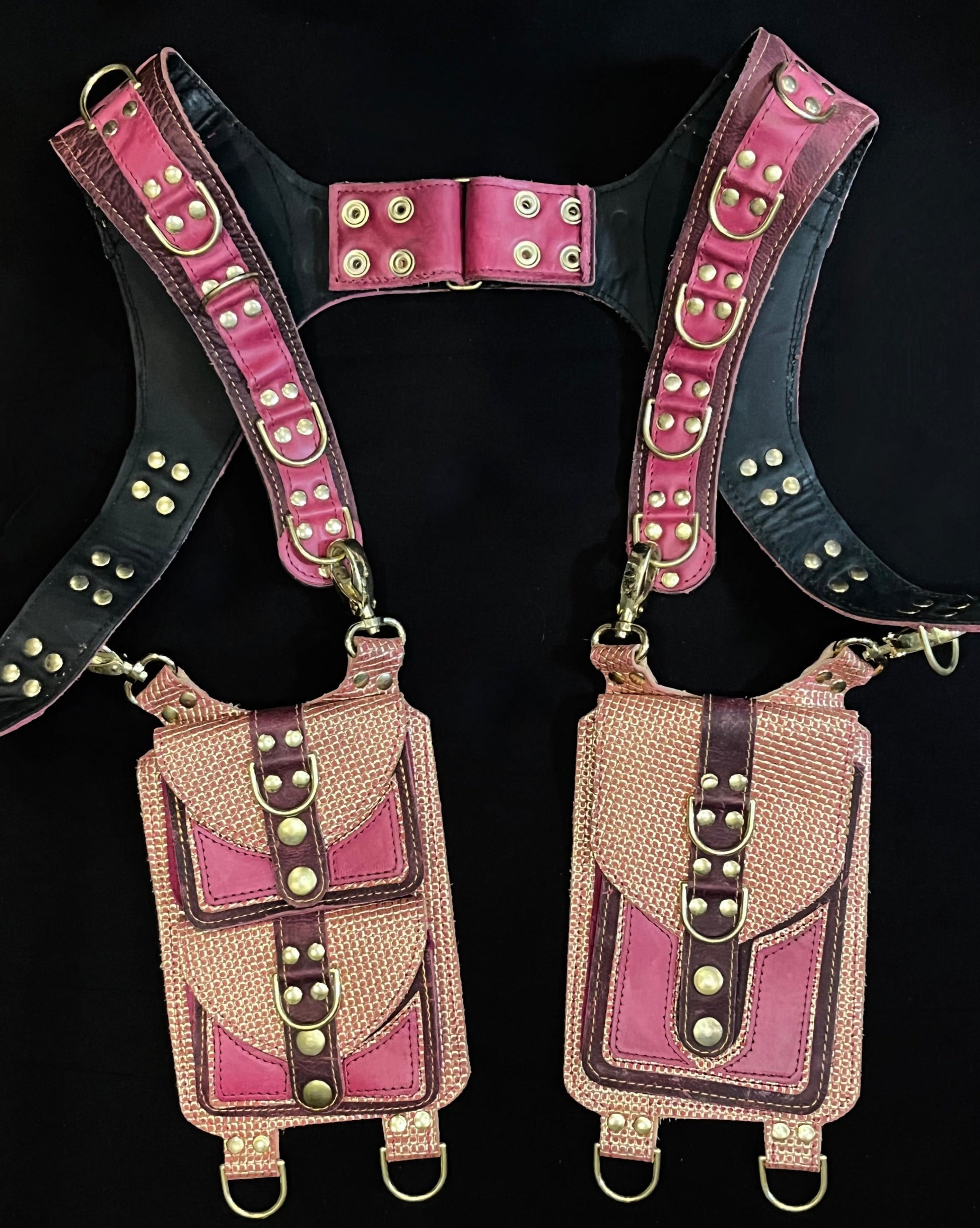 front view of pink, plum, and peach and gold leather holster with hanging pockets and brass hardware