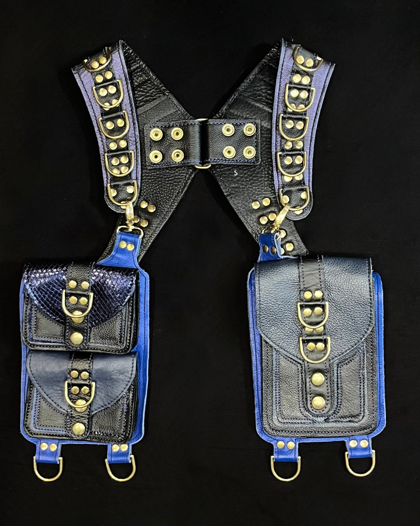 front view of blue and black leather holster with hanging pockets and brass hardware