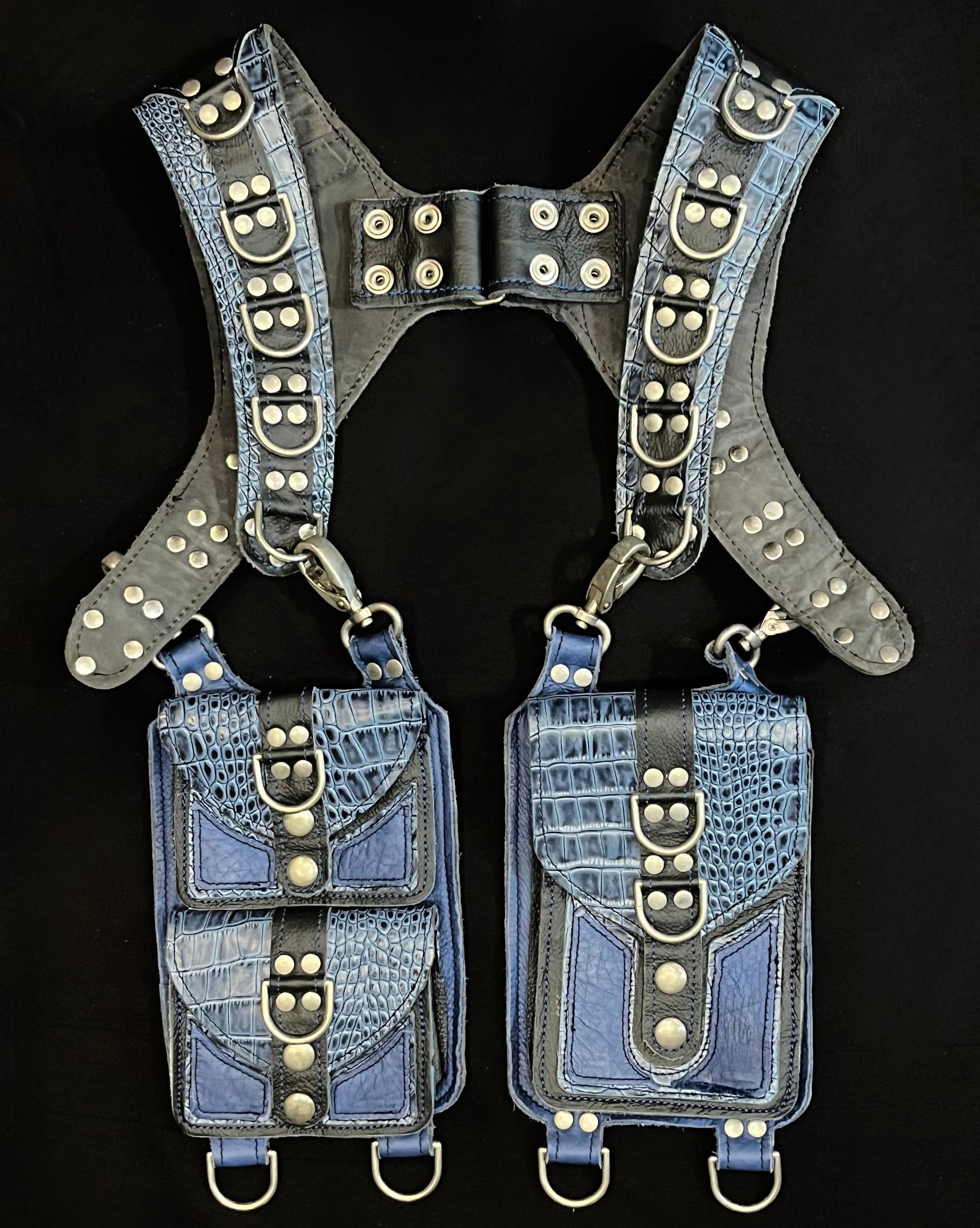 front view of blue croc and black leather holster with hanging pockets and nickel hardware