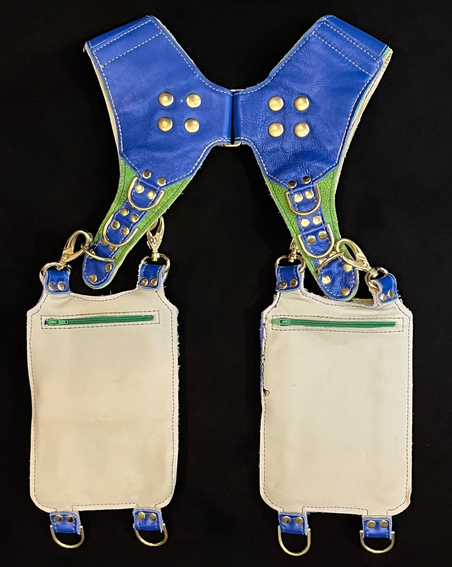 back view of green and blue leather holster showing hidden zipper pockets on hanging pockets