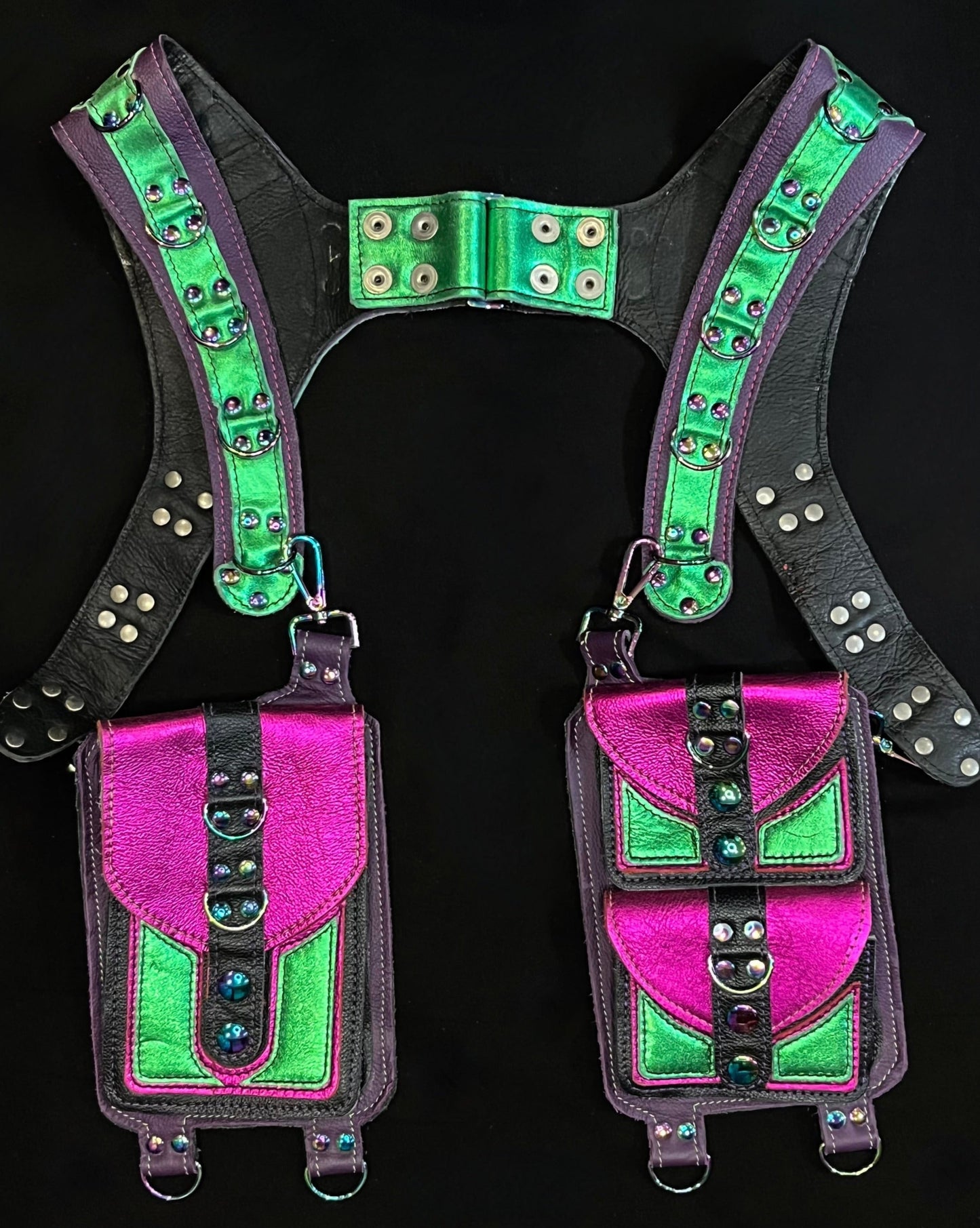 front view of black, magenta, and green leather holster with hanging pockets and rainbow hardware