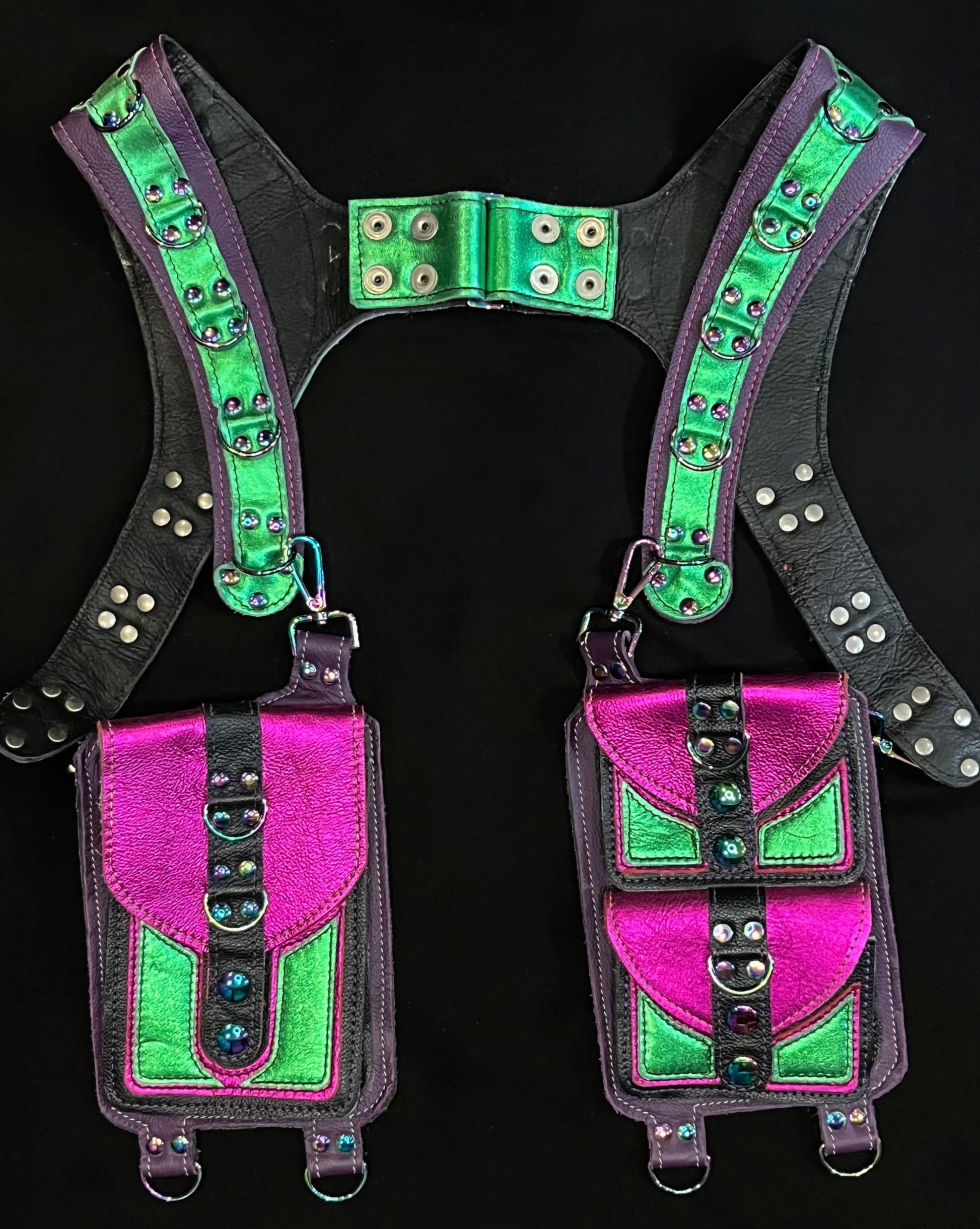 front view of black, magenta, and green leather holster with hanging pockets and rainbow hardware