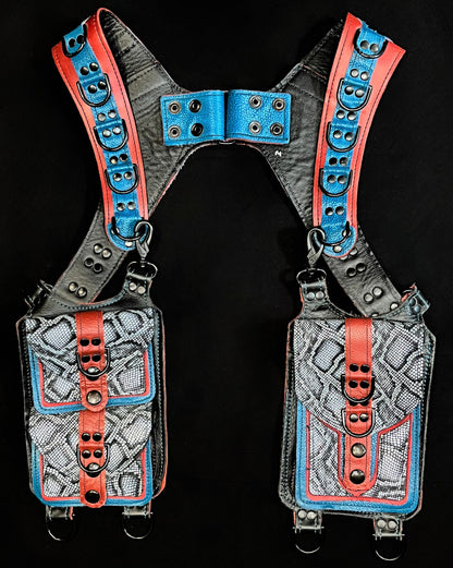 front view of terracotta, blue, and python leather holster with hanigng pockets and black hardware