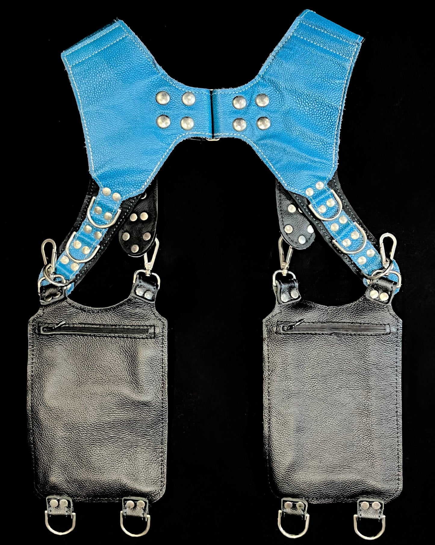 back view of black, teal, and silver leather holster showing hidden zipper pockets on hanging pockets