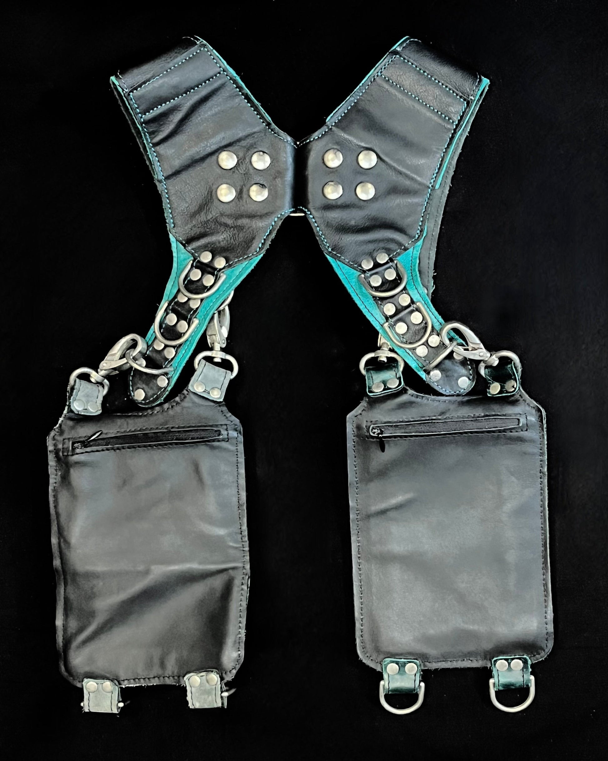 back view of black and mismatched teal and blue leather holster showing hidden zipper pockets on hanging pockets