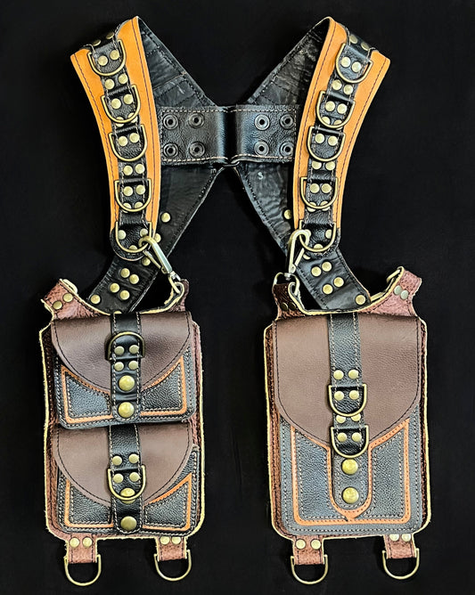 front view of black, brown, and ochre leather holster with hanging pockets and antique brass hardware