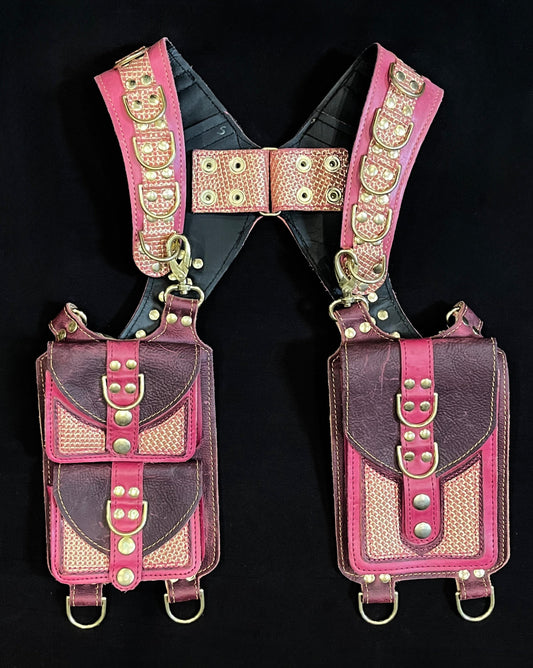 front view of pink and plum leather holster with hanging pockets with brass hardware