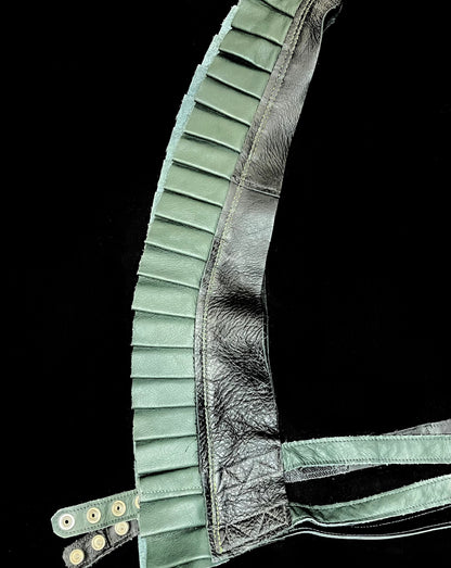 black and forest green leather ruff top laid flat on its side against a black background