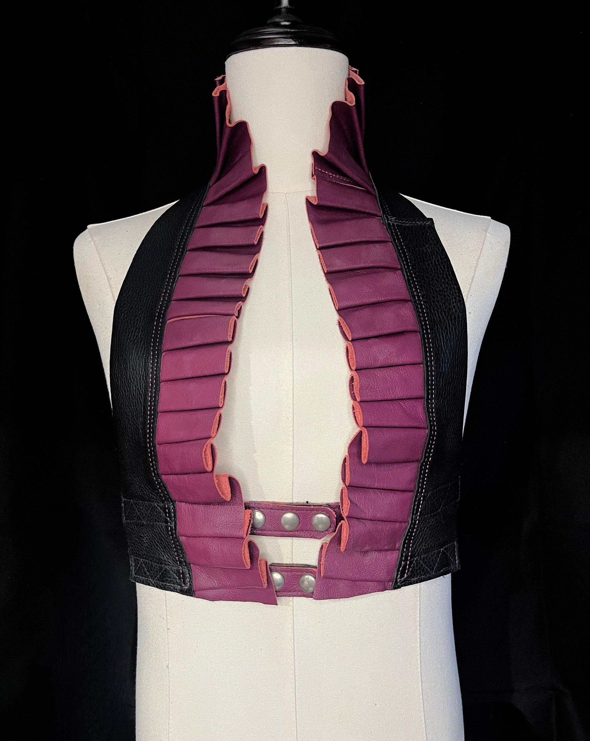 dark rose and black leather ruff top with nickel hardware on an ivory non-gender mannequin against a black background