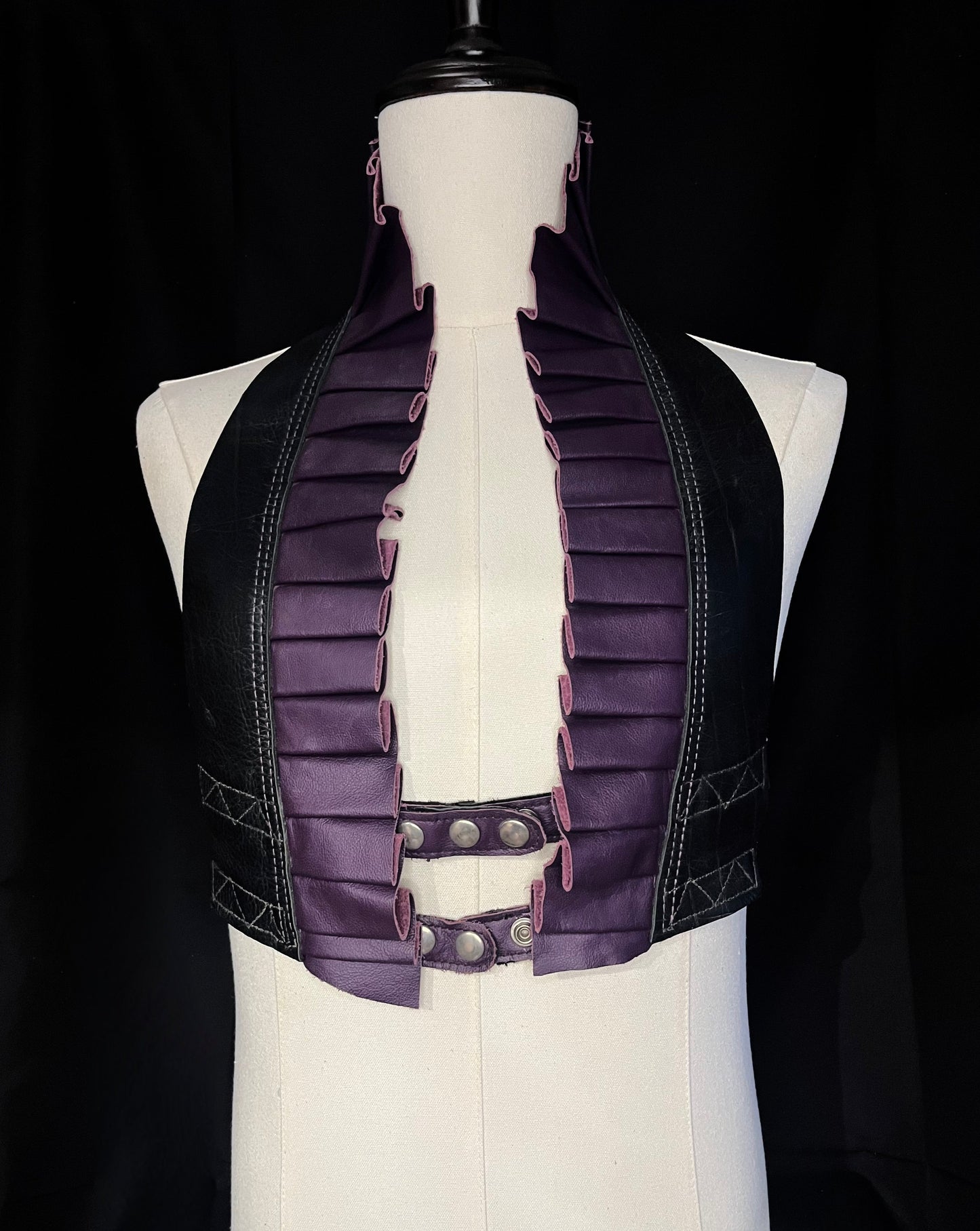 black and purple leather ruff top with nickel hardware on an ivory gender neutral mannequin against a black background