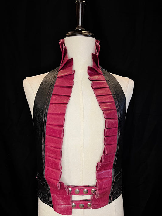 Bright rose leather ruff with a black leather neck and nickel hardware on a ivory non-gender mannequin against a black background