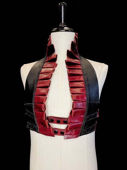 Cabernet oxblood red leather ruff with a black leather neck and black hardware on an ivory non-gender mannequin against a black background