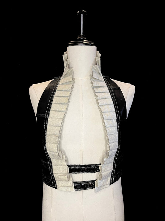 Ivory leather with ivory lace overlay ruff with a black leather neck and black hardware on an ivory non-gender mannequin against a black background