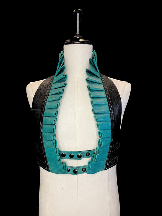 Turquoise leather ruff with a black leather neck and black hardware on an ivory non-gender mannequin against a black background