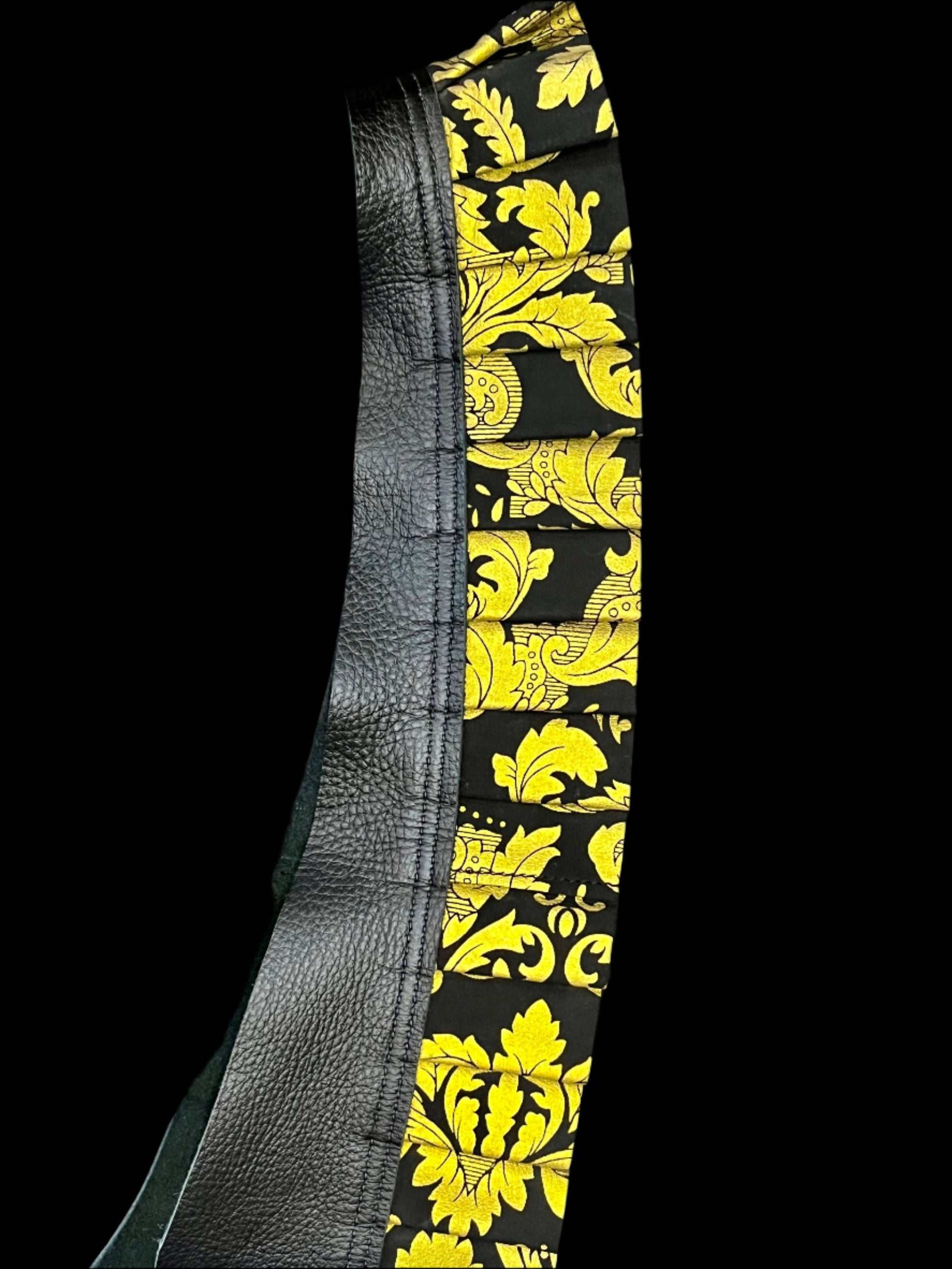 black and gold damask printed leather ruff with a black neck on its side on a black background