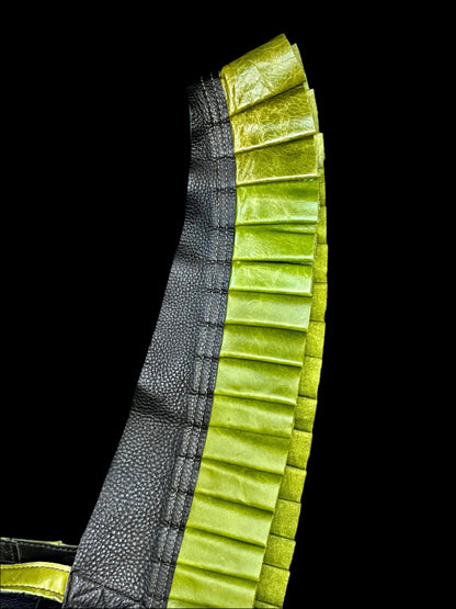 apple green leather ruff with a black leather neck on its side on a black background