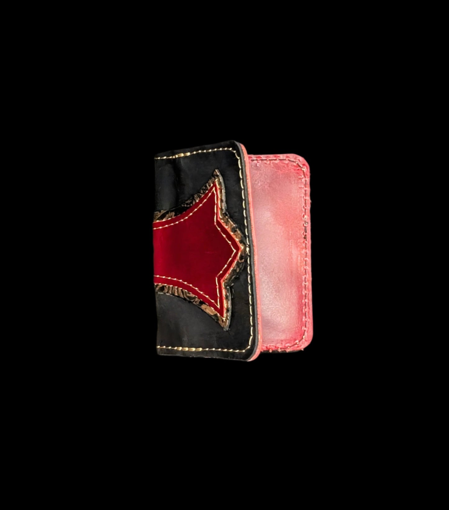 A wallet folded in half showing a base color of black leather with a layered trident accent in bronze floral and red leather with red and bronze stitching.