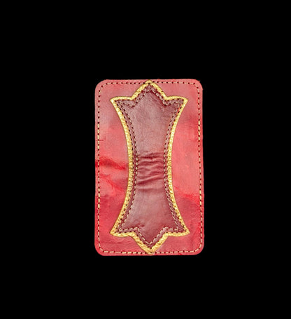 A photo of the outside of a wallet laid flat showing a base color of red leather with a layered trident accent of bronze leather and red leather and red and bronze stitching. 