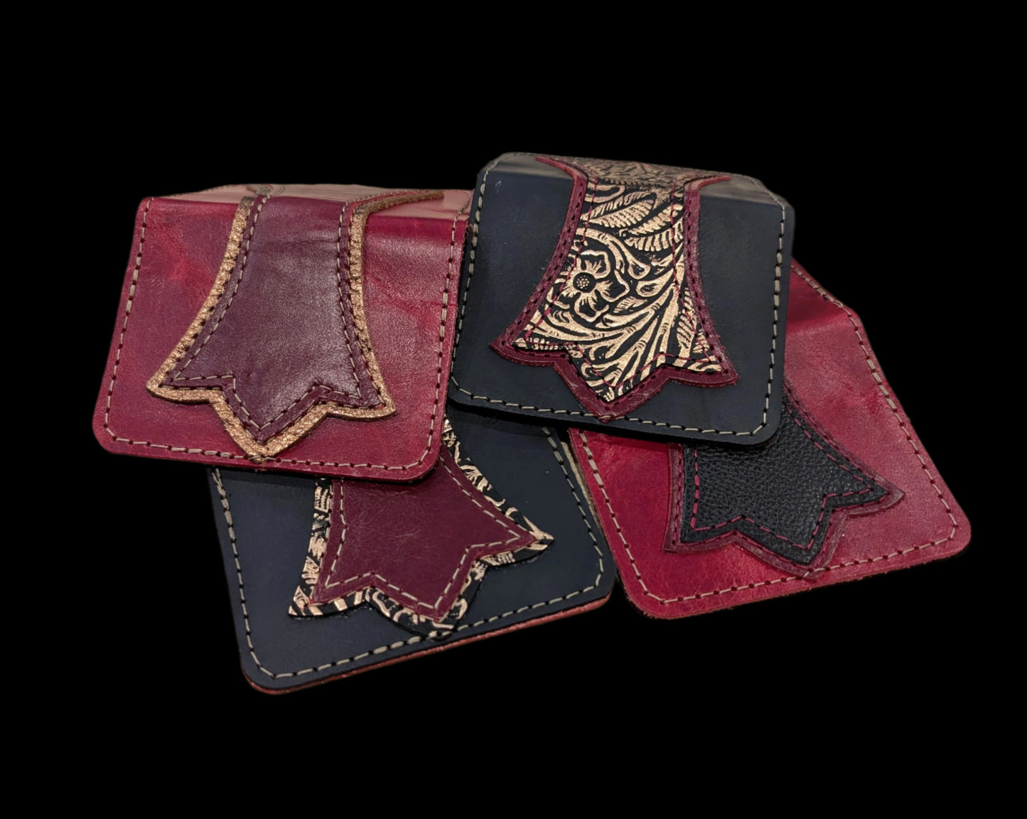 Stack of rose rouge wallets. Variants include colors of black, red and bronze floral leather with red and bronze stitching