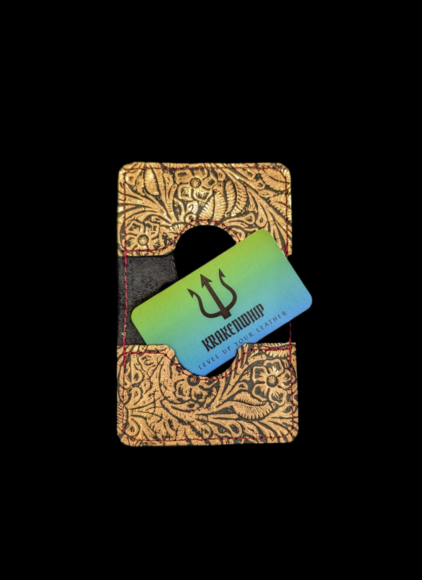 A wallet spread open showing a base color of black leather with two card pockets in floral bronze leather with red stitching.  A krakenwhip business card is sticking out of one of the pockets.