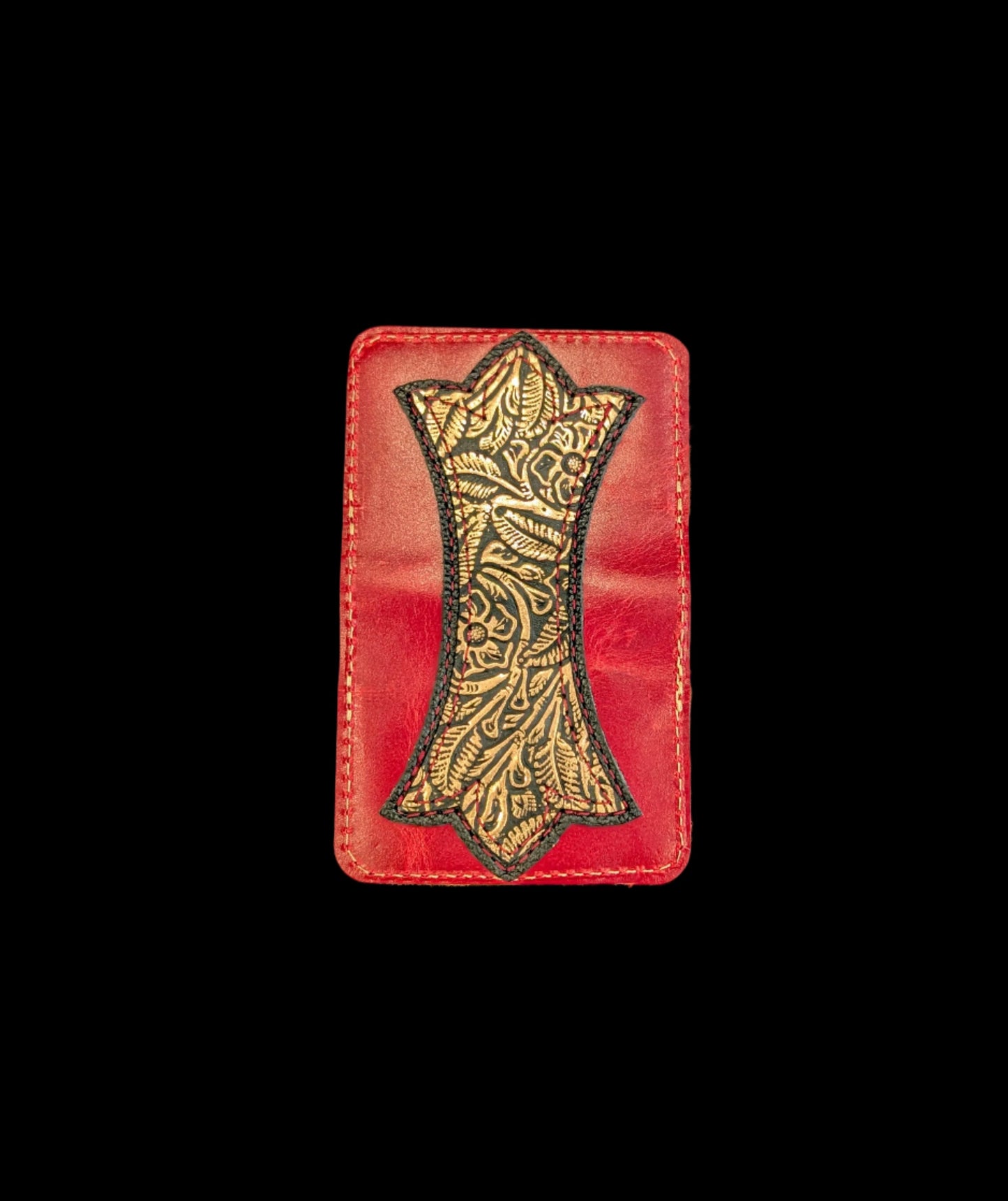 A photo of the outside of a wallet laid flat showing a base color of red leather with a layered trident accent of black leather and bronze floral leather and red and bronze stitching. 