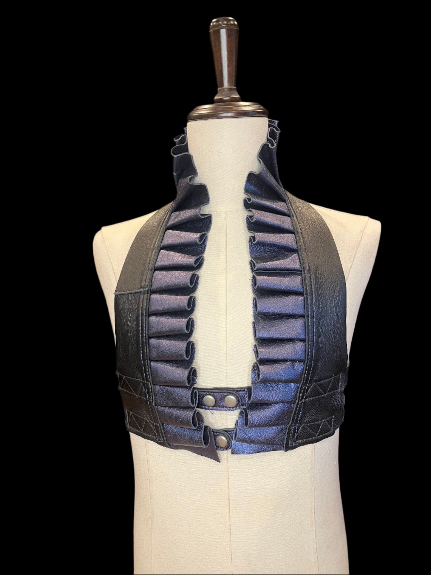 Black and metallic sapphire leather ruff top on an ivory gender neutral mannequin against a black background