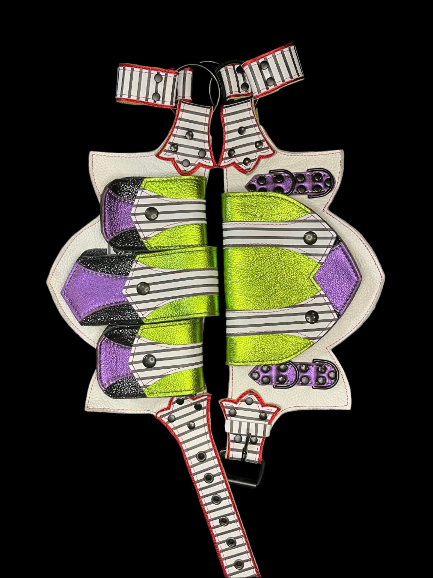 Leather regal belt laid flat showing black and white striped, metallic lime, metallic purple, and metallic red leather and black hardware on a black background