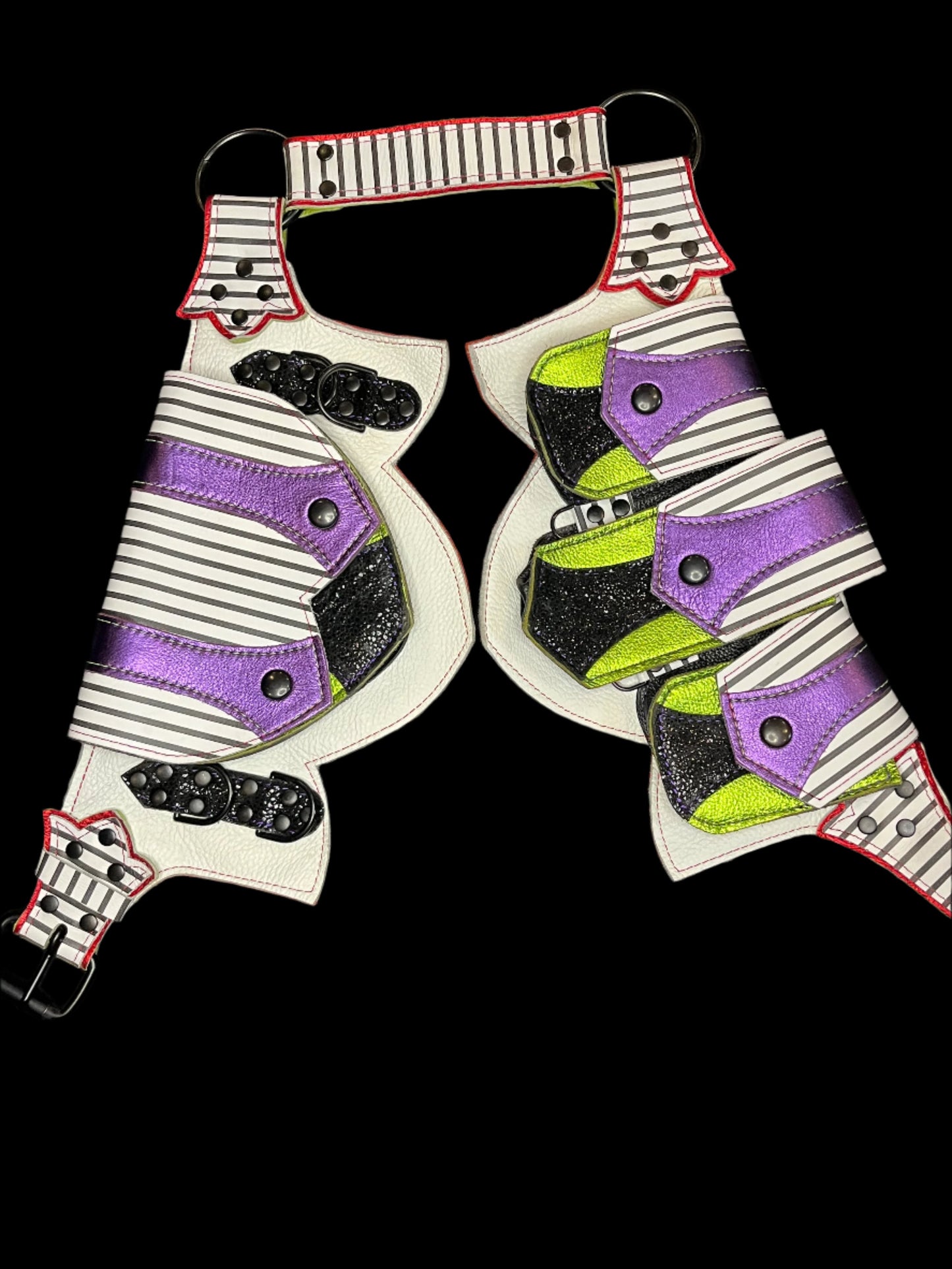 Leather regal belt laid flat showing black and white striped, metallic lime, metallic purple, and metallic red leather and black hardware on a black background