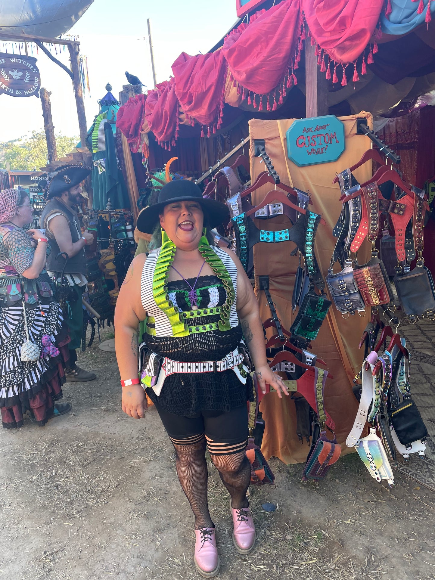 femme individual standing in front of ren faire booth smiling while wearing Showtime ruff and belt